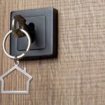 House key with house keychain in the door