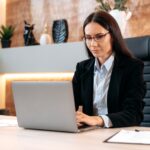 Intelligent caucasian beautiful brunette woman with glasses, in a formal suit, top manager, realtor